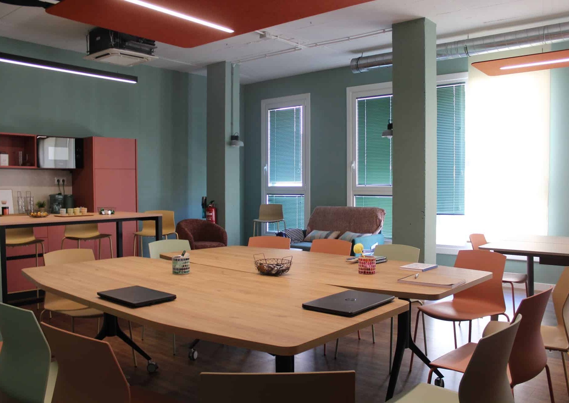 Sala de eventos en Amara con dos mesas unidas formando una gran mesa de juntas, rodeada de sillas de diseño y con vistas al office.