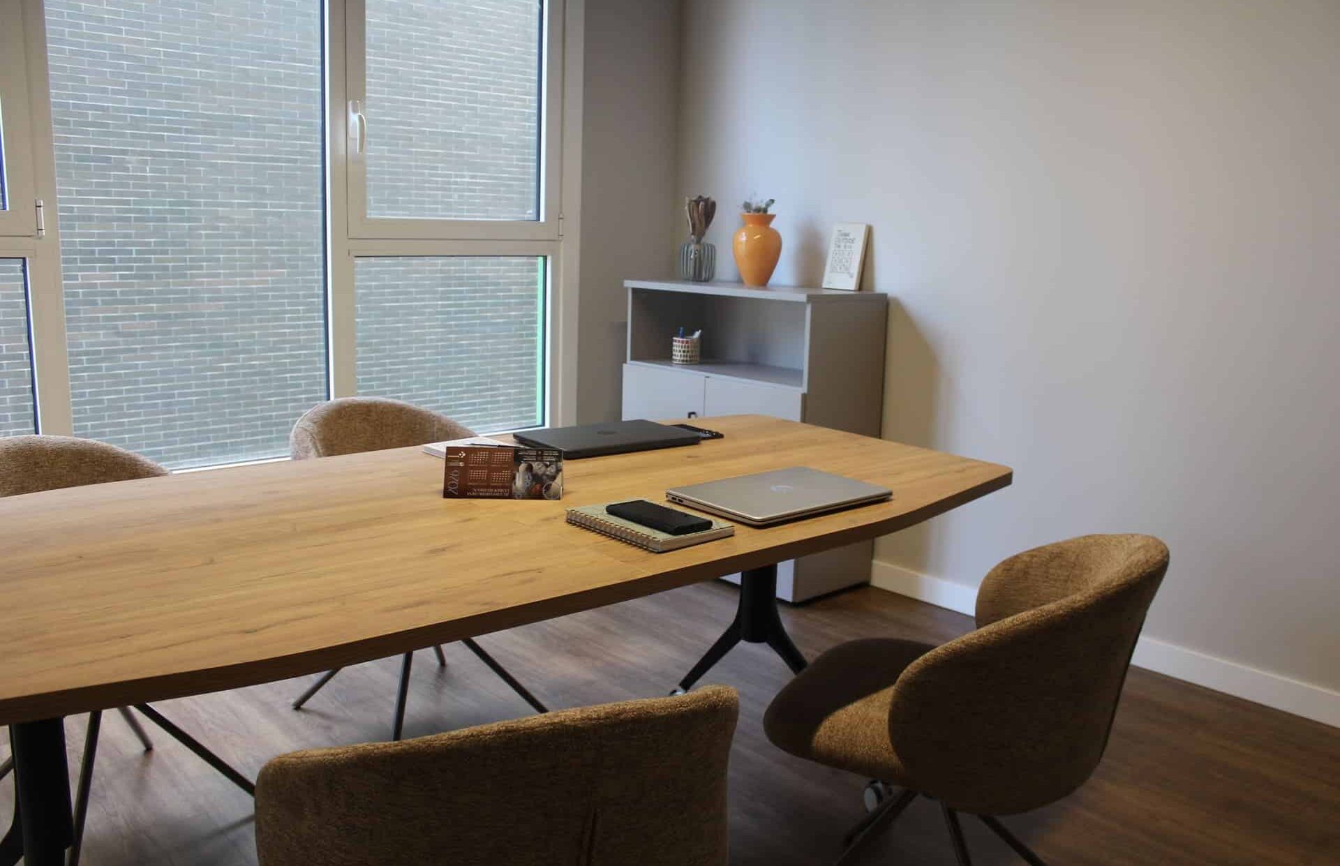 Sala de reuniones en Coworking Kbiak en Amara para 4 personas, con mesa de madera, sillas ergonómicas y luz natural, cerca de Ayete y el Centro.