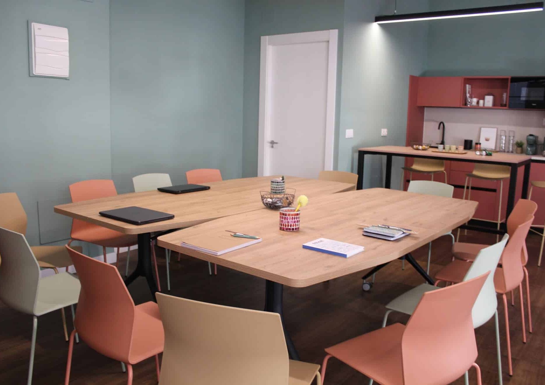 Mesa grande de madera configurada para reunión de trabajo o clases particulares en Kbiak Amara.