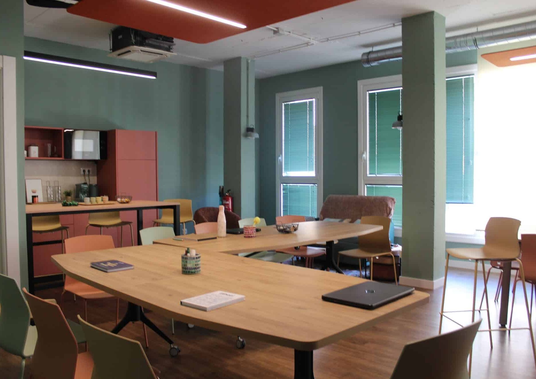 Sala de eventos en Kbiak Amara con mesa en forma de L, ideal para talleres dinámicos y presentaciones cerca de Ayete.