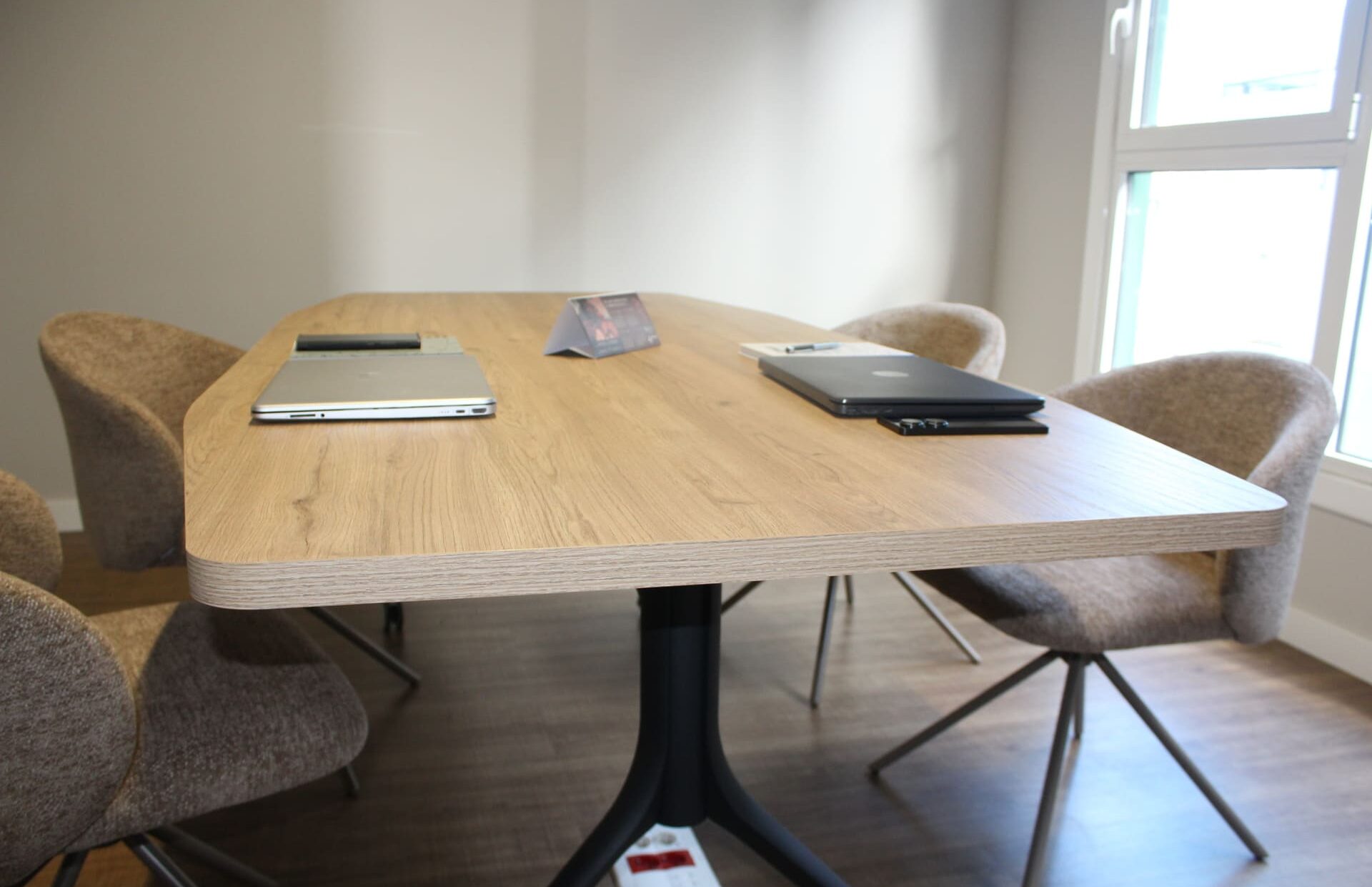 Sala de reuniones en Coworking Kbiak con mesa de madera, sillas ergonómicas de tela y luz natural en Amara.